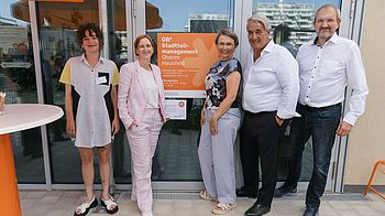Fünf Personen stehen vor dem neuen Stadteilmanagmentlokal im Oberen Hausfeld